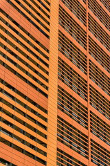 Building exterior with terracotta wall cladding at Austin, Texas. Close-up of an orange wall...