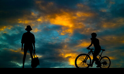 Fototapeta na wymiar Silhouette of young man riding on modern bike on the road with bright cloud sky background, Sport and active life concept in the summer ,