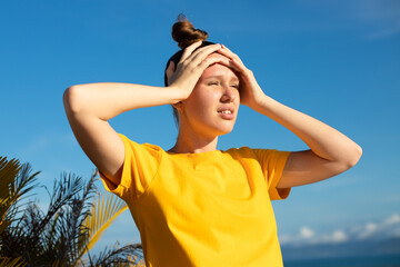 Girl is suffering from heat, woman with heatstroke. Having sunstroke at summer hot weather....