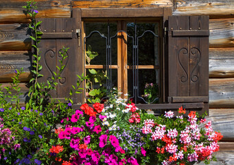 Fototapeta na wymiar colorful flower window on a wooden house