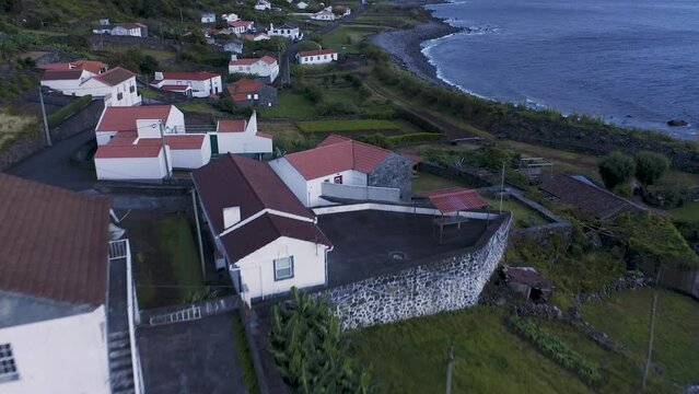 rural coastal village in lush green cliffs on blue hour, Faj&atilde; dos Vimes, S&atilde;o Jorge island, the Azores, Portugal