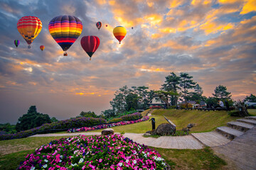 Cumulus clouds and golden sunlight on mountain with hot air balloons on morning at Thailand. Huai...