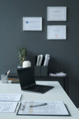 Vertical image of workplace of manager with resumes of candidates on table during job interview