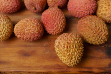 group of fresh lychees on a wooden board
