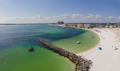 East Jetty in Destin Florida with buildings and cloudy sky view in background. Beautiful aerial...