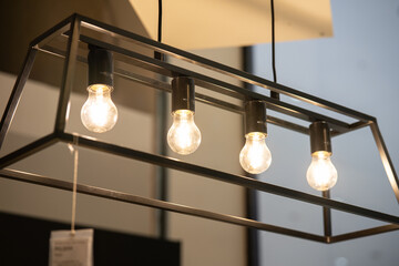 Several hanging lights with retro bulbs. a decorative lamp that has a simple but elegant design with a golden color combined with several light bulbs. 