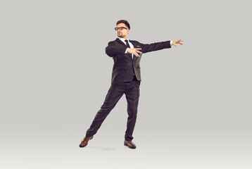 Serious office worker, corporate employee or businessman dancing in studio. Full body shot of...