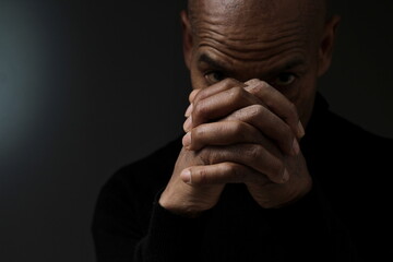 man praying to god with grey black background with people stock photo