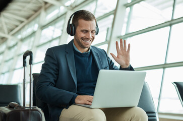 Computer call, wave and business man at an airport in a online meeting ready for work travel....