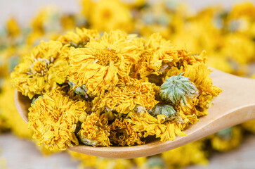 A Dried Chrysanthemum tea in wooden spoon
