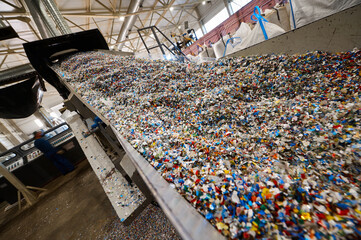Chopped waste plastic transported by production line - obrazy, fototapety, plakaty