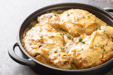 Tasty hot Southern Smothered Pork Chops in Brown cream onion Gravy  closeup on the pan on the table. Horizontal