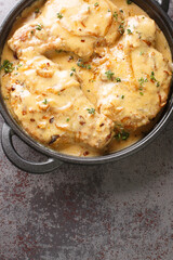 Savory Southern Style Smothered Pork Chops closeup on the pan on the table. Vertical top view from above