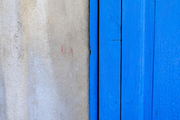 Blue Wooden Door with Old Grunge Concrete Wall Background.