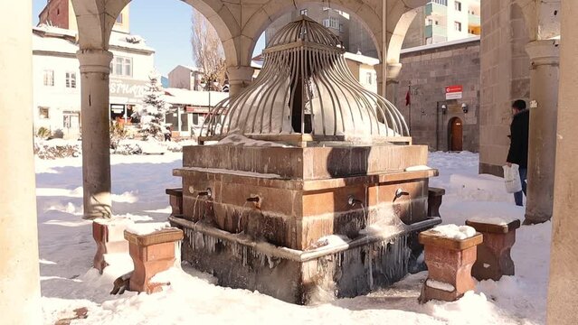 Erzurum in Turkey. 02.02.2023 Ancient water source (Turkish: Su Kaynak), close to Muratpasa mosque for ablution before prayer. Islamic ancient building, cold weather in winter -50 C. Snow, Freeze, ice