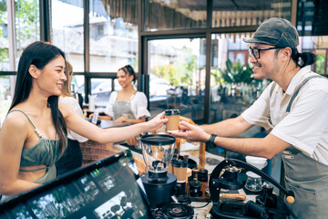 Asian attractive women receive hot coffee from waiter in coffee house.