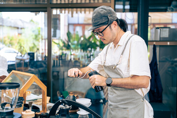 Portrait of Asian attractive barista or waiter working in coffeehouse. 