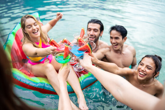 Group of diverse friend drinking alcohol, having a pool party together. 