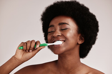Toothbrush, brushing teeth and black woman for clean and healthy mouth on studio background. Face...