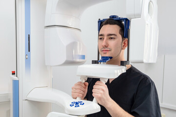 Patient is scanned by 3d dental white equipment X-ray system equipment in modern dental clinic. Interior in dental stomatologist office. High quality close up photo. 