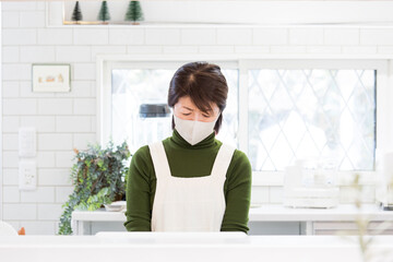 体調不良の日本人主婦、風邪、マスク姿で家事