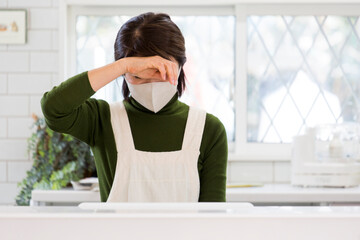 体調不良の日本人主婦、風邪、マスク姿で家事 © kazoka303030