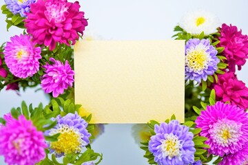 白、赤と紫のアスターの花々で飾った可愛い黄色のコメントスペースのモックアップ