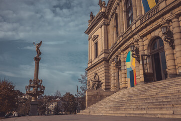 side view of rudolfinum, philharmony hall of czech republic in prague. visible stairs and a statue in front.