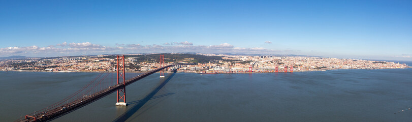 Panoramic landscape of the April 25 bridge over the Tagus river and the Lisbon city in the background