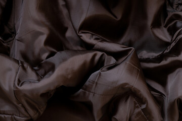 Brown winter men's jacket as a background close up, fashionable clothes, brown background