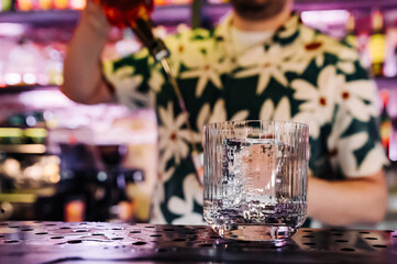 empty glass with ice on a bar counter in bar or pub