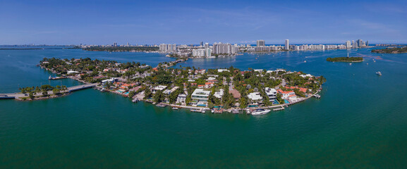 Intracoastal Waterway with waterfront homes and buildings in Miami Florida. Aerial view of a man-made inland water channel with city skyline against blue sky.