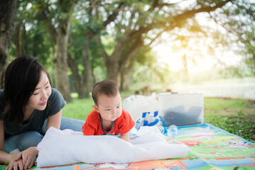 Happiness asia mother and baby having a picnic outdoor in the park