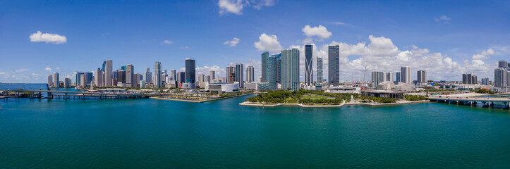 Fototapeta na wymiar Panorama of city skyline and Intracoastal Waterway in Miami Beach Florida. Beaautiful buildings and skyscrapers surrounded by inland water channel against blue sky and clouds.