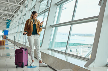 Luggage, travel and woman with phone at airport for social media, web scrolling or internet...