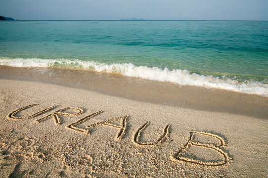 the word 'Urlaub' scratched into sand at beach, Koh Lipe, Thailand