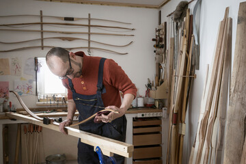 Male bow maker making bow in workshop, Bavaria, Germany