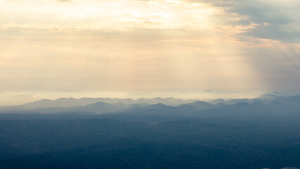 Landscape of sunbeam shining on blue mountain range.