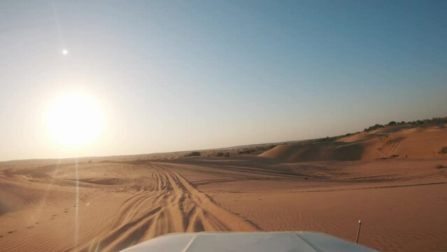 4K POV of a vehicle dune bashing on the sand dunes of the Thar desert at Jaisalmer in Rajasthan, India. Car moves on the desert during the day. Extreme adventure in the desert background.