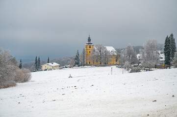 Neunkircher hoehe near darmstadt during winter with lots of snow and yellow church in the background, cloudy day, germany