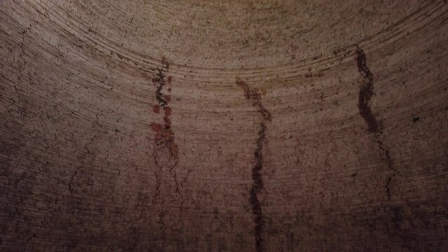 Brick kiln empty interior, Vinh Long province in the Mekong Delta, Vietnam. Stabilized shot tilts down from the top of the dome and opening to the floor with texture and circular pattern and light.