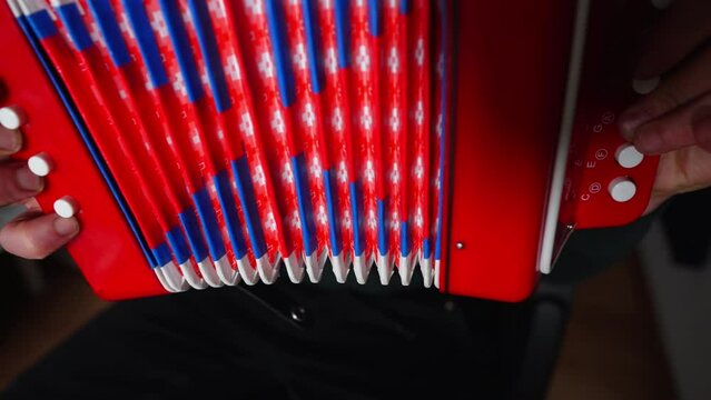 Man playing childrens red musical bayan accordeon. High quality 4k footage