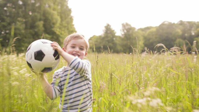 Little boy playing with soccer ball in park