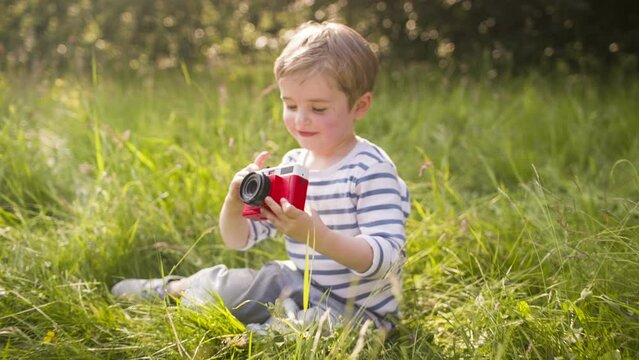 Little boy enjoys taking photos with toy camera