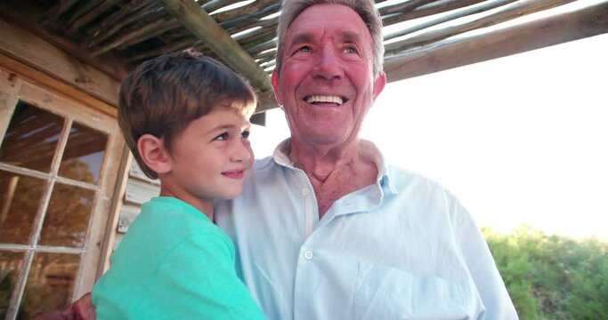 Elderly grandfather and loving grandson smiling and hugging each other outdoors, Panning in Slow Motion