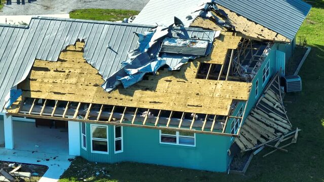 Hurricane Ian destroyed house roof in Florida residential area. Natural disaster and its consequences