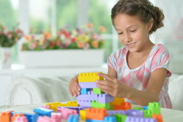 little girl playing with colorful plastic blocks