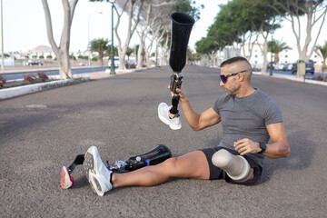 Male runner changing leg prosthesis before training