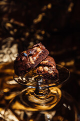 Seductive sneakers on a golden background. Dark lighting. Nuts,glass