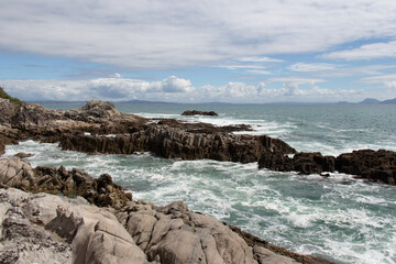 Fototapeta na wymiar Seascape with rocks and blue sea in a sunny day, near Mangawhai Heads, Auckland, New Zealand.